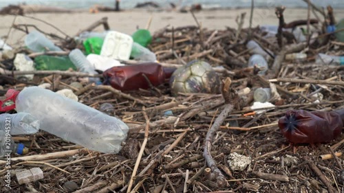 Wallpaper Mural Ecological catastrophe of the sea. Slide a lot of plastic bottles, garbage on the sandy beach of the Black Sea. Bokeh moving waves in the background. Environmental pollution Torontodigital.ca