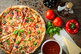 Italian pizza and ingredients on wooden table