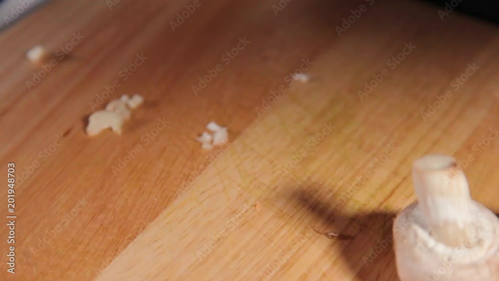 A close up shot of mushroom being chopped by a woman. A close up shot of mushroom being chopped by a woman.