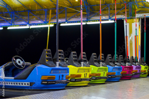 A line of colorful, electric bumper cars in autodrom in the fairground attractions at an amusement park. © mirkoni
