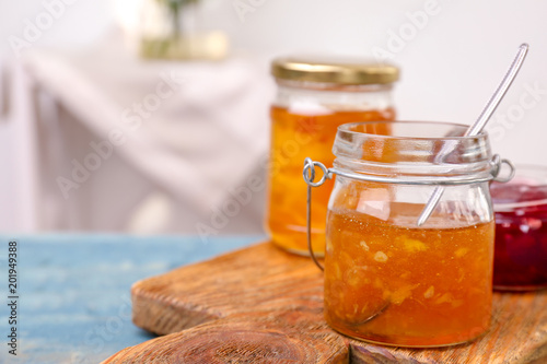 Jars with tasty sweet jam on wooden table