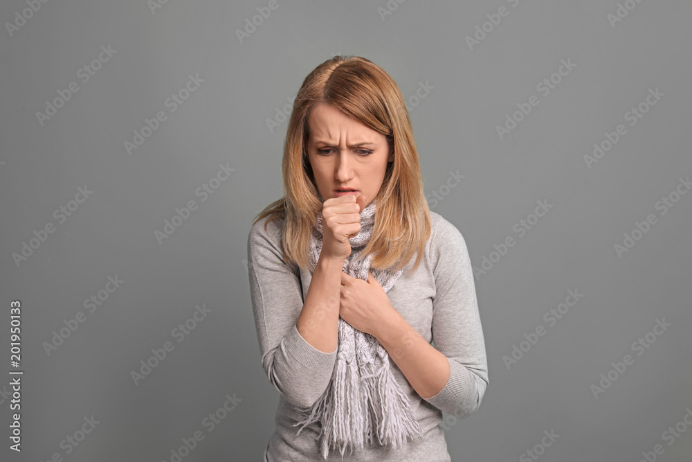 Young woman coughing on color background Young woman coughing on color background