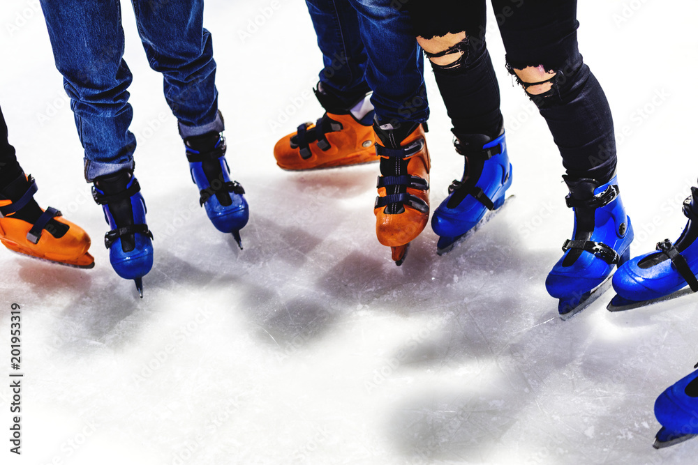 Feet closeup of group of friends ice skating together Feet closeup of group of friends ice skating together