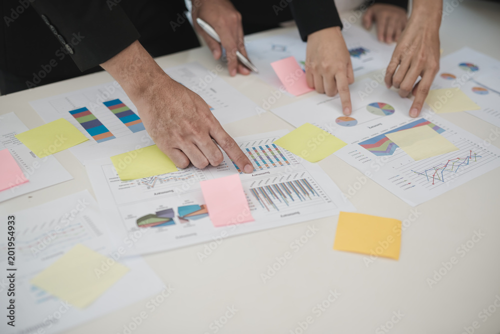 Hand of Business man and Business woman working on Data Charts,document at office desk. analyzing brainstorming, meeting concept.. Hand of Business man and Business woman working on Data Charts,document at office desk. analyzing brainstorming, meeting concept..