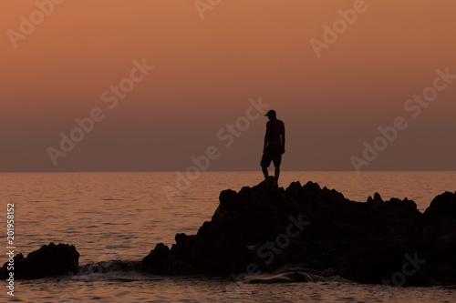 Man contemplating life on coastal rocks