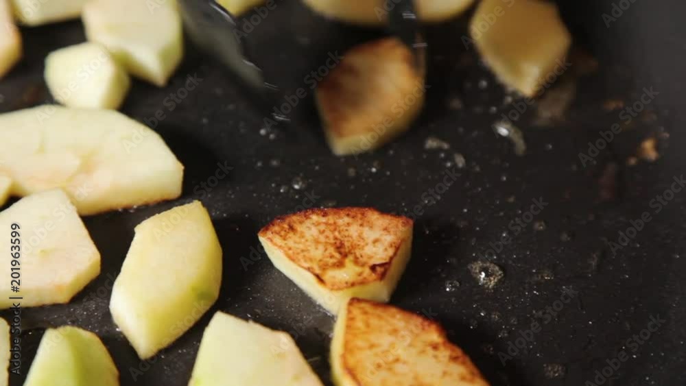 A close up shot of apples being fried on melted butter. A close up shot of apples being fried on melted butter.