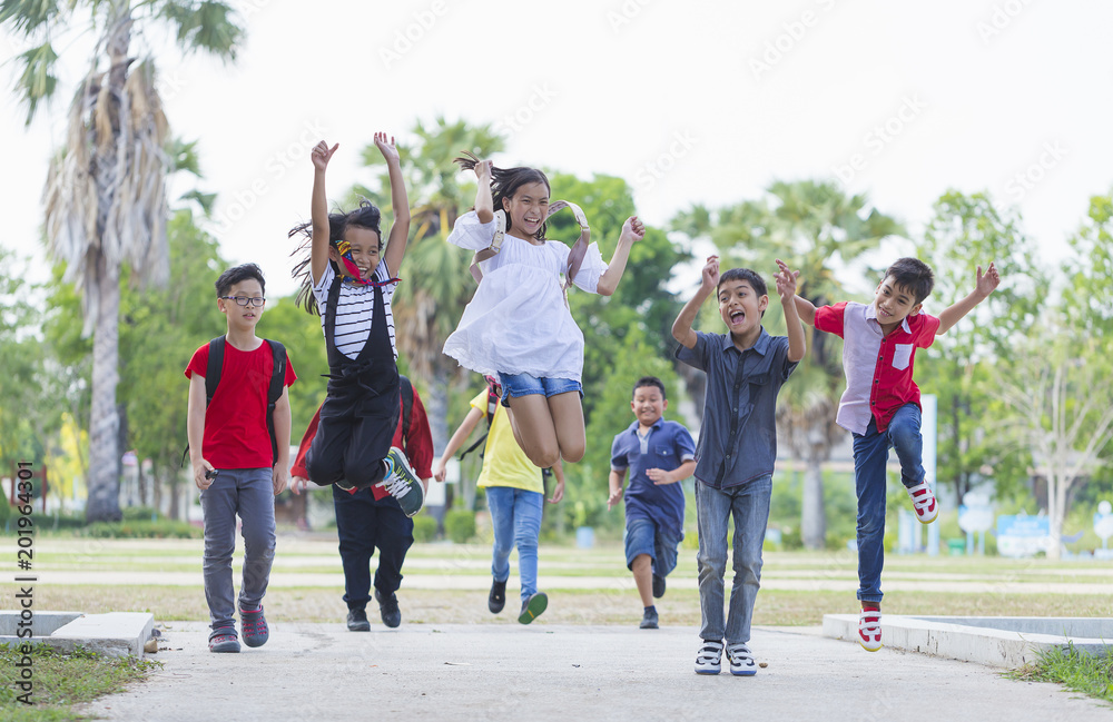 happy MultiEthnic children run to playground after summer school. 11-12 years old children group jumping on outdoor. Education Children Kids Playing Celebration Happiness Cheerful Concept happy MultiEthnic children run to playground after summer school. 11-12 years old children group jumping on outdoor. Education Children Kids Playing Celebration Happiness Cheerful Concept