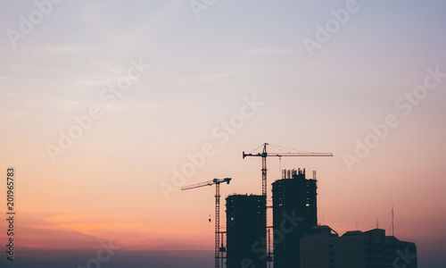 Silhouette construction  site over blurred background sunset pastel for industry background with Light fair.Grain Effects