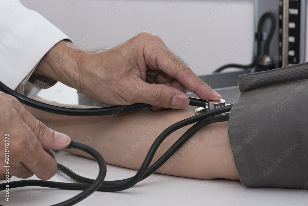Doctor measuring blood pressure of a patient Doctor measuring blood pressure of a patient