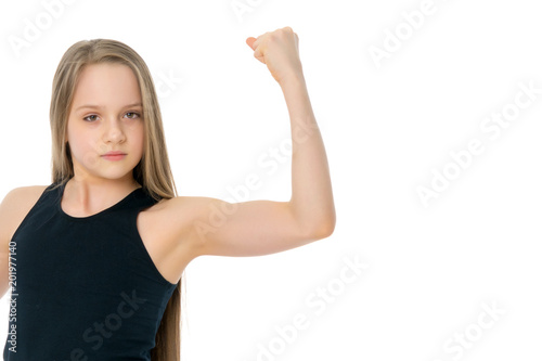 A little girl shows her muscles.