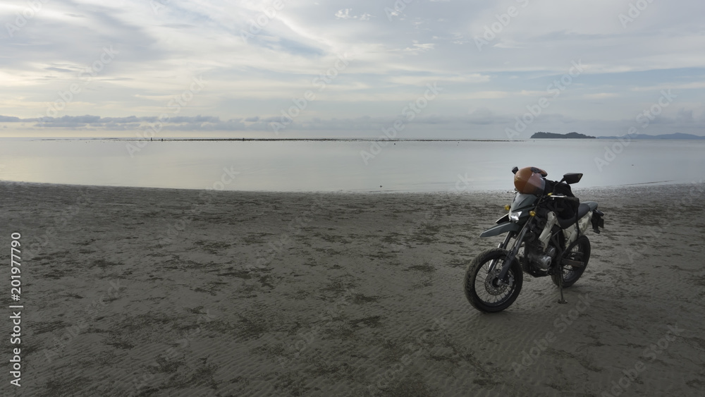 motorcycle on beach and near ocean. adventure style.