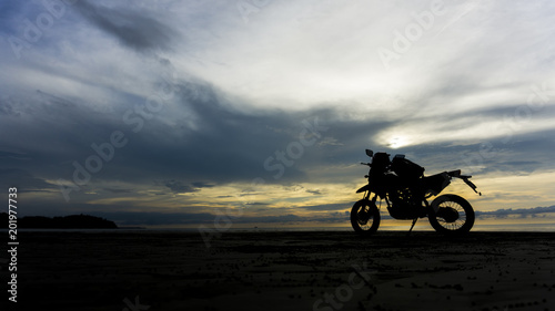 motorcycle on beach and near ocean during sunset. adventure style.