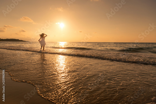 Summer lifestyle of pretty woman wear white dress having fun and relax on beach. Positive emotions. Summer concept.