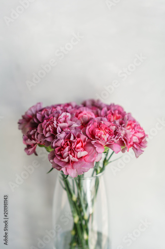 Fototapeta Naklejka Na Ścianę i Meble -  beautiful carnation flowers in a vase on a table . Bouquet of violet, purple and pink multicolor flower. Decoration of home. Wallpaper and background. Vertical photo