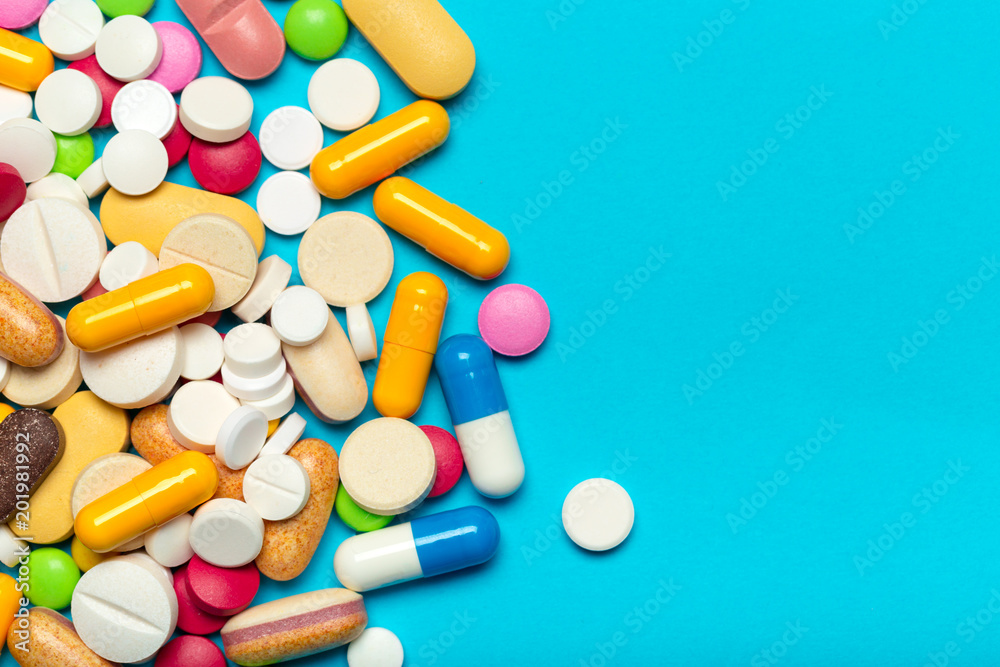 Pills are scattered over a blue background Pills are scattered over a blue background
