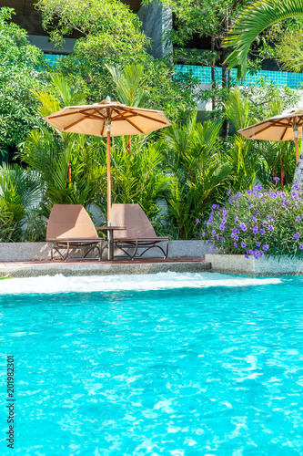 Beautiful umbrella and chair around swimming pool in hotel and resort - vacation concept