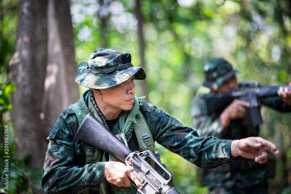 Squad of soldiers patrolling across the deep forest area.