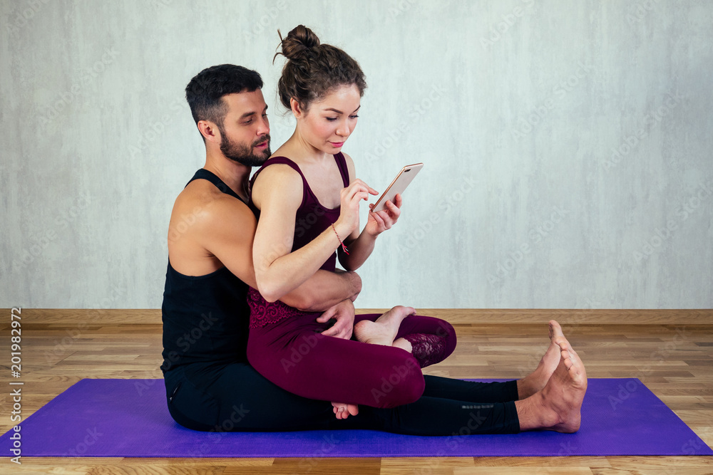 beautiful and young woman with curly hair and a sexy man doing selfie on  yoga mat in floor. the concept of yoga in a pair and tantric yoga Stock  Photo | Adobe