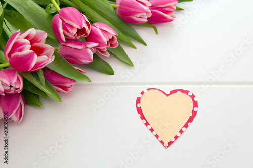 Mother's Day card and a bouquet of beautiful tulips on wooden background.