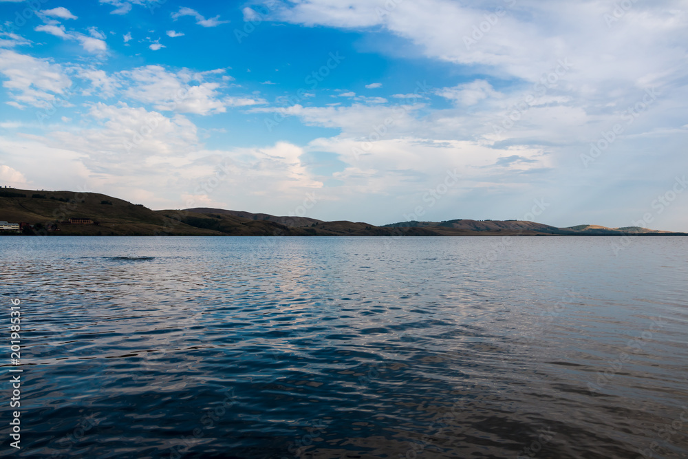 Lake and white clouds under lake in a sunny day