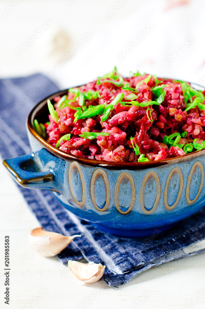 Buckwheat stewed with beetroot in a bowl on a wooden table Buckwheat stewed with beetroot in a bowl on a wooden table