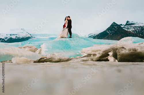 Iceland Ice Beach Or Jokulsarlon Iceberg Beach - Newlyweds is standing on Iceberg