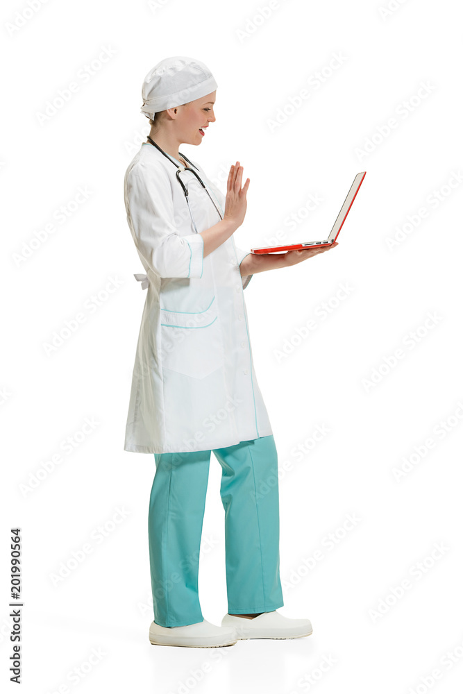 Beautiful young woman in white coat posing at studio. Full length studio shot isolated on white.