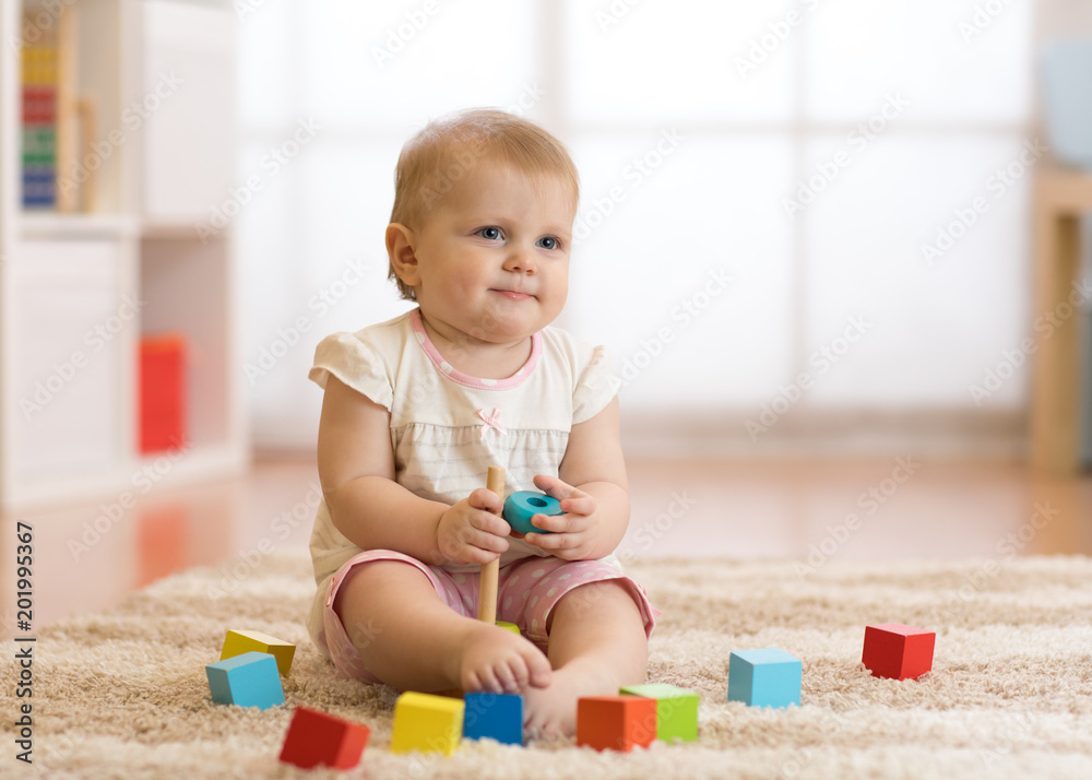 Cute baby toddler girl playing with wooden toys and having fun. Cute baby toddler girl playing with wooden toys and having fun.