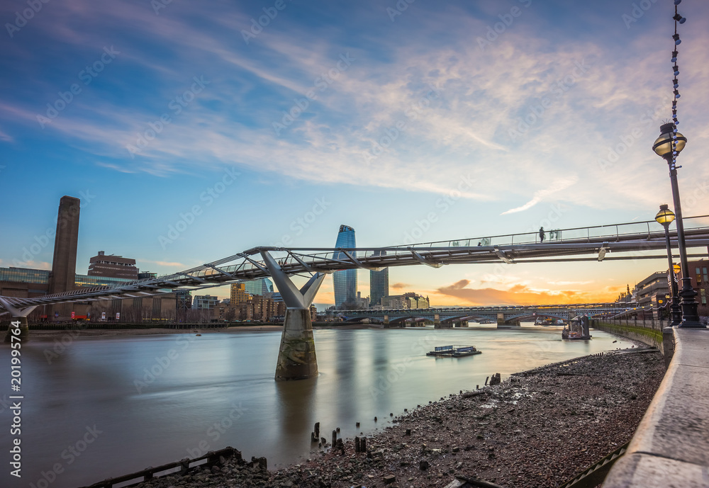London, England - Beautiful sunset at Millennium Bridge with River Thames and skyscrapers at background