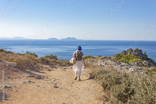 woman walking on a path to reach the sea
