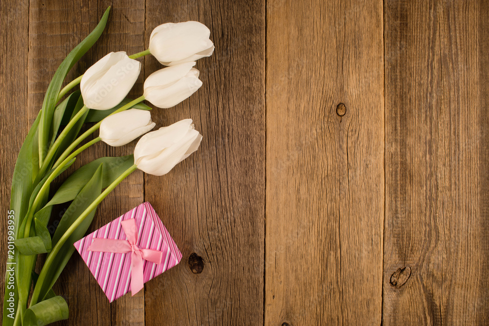 White tulips on rustic wooden background. Gift box.