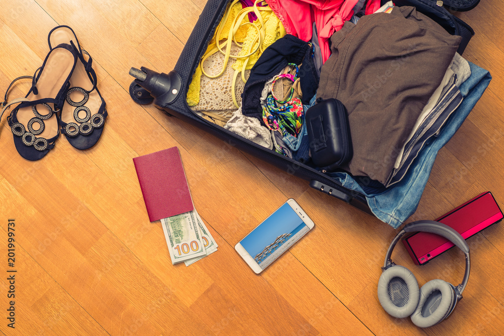 A suitcase with things and foreign passport. Asian money and hundred-dollar bills for travel. Concept A suitcase with things and foreign passport. Asian money and hundred-dollar bills for travel. Concept
