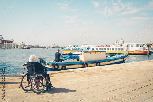 Disabled person in wheelchair looking at sea. Venice, Italy. photo