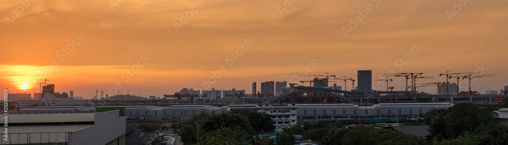panorama of sunset in cityscape and construction site