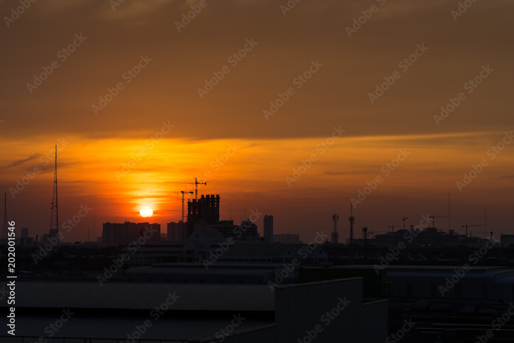 sunset orange sky cityscape and construction site silhouette