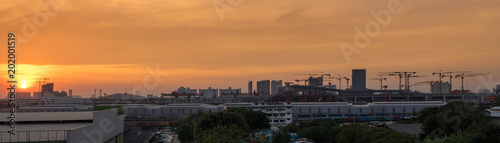 panorama of sunset in cityscape and construction site
