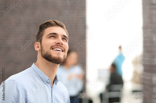 Smiling businessman in profile on office background,