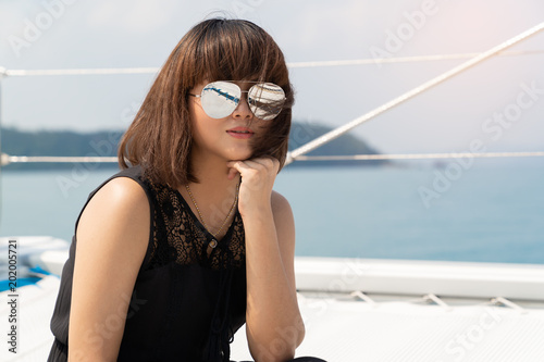 Asian beautiful woman portraits on luxury yacth in the sea and blue sky background. © mikumistock