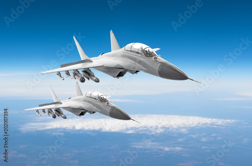 Pair of military fighters jet aircraft on a combat mission, flying high in the sky.