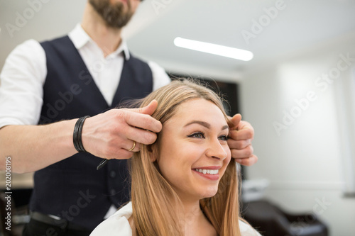 Hairdresser holding happy customer hair