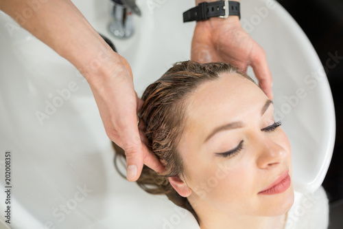 Young woman having hair washed before hair cut