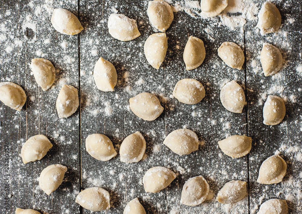 Pelmeni, dumplings with meat on dark wood background. Fresh dough. Pelmeni, dumplings with meat on dark wood background. Fresh dough.
