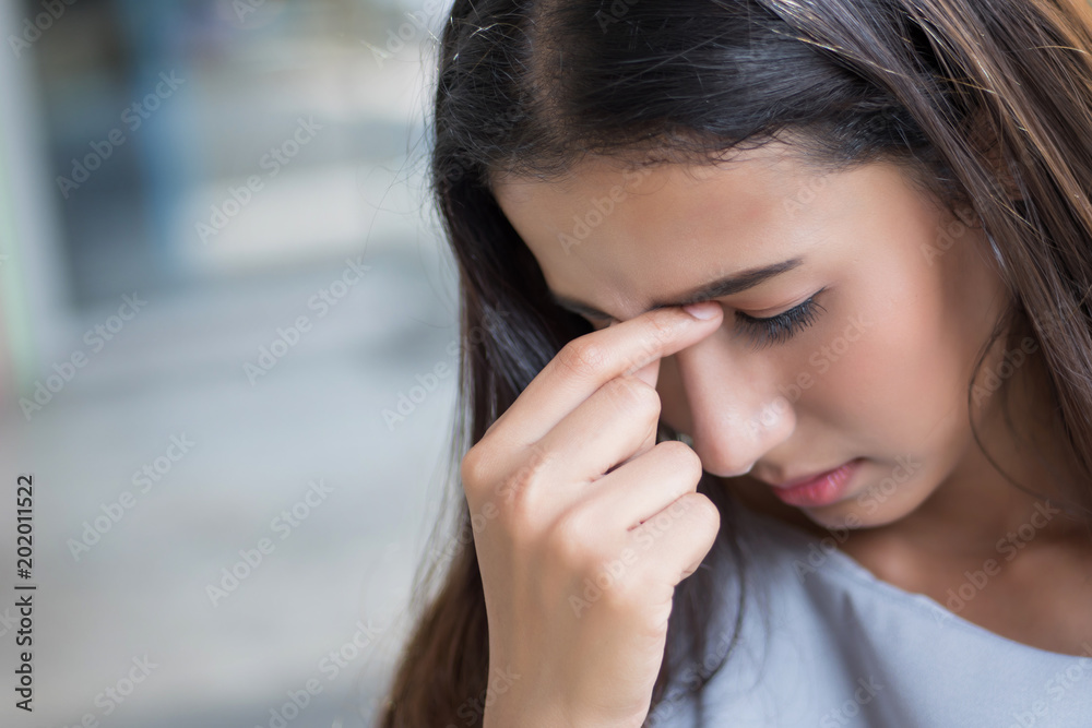portrait of stressed sick woman with headache; ill woman suffers from vertigo, dizziness, migraine, hangover, health care concept; young adult asian woman model portrait of stressed sick woman with headache; ill woman suffers from vertigo, dizziness, migraine, hangover, health care concept; young adult asian woman model