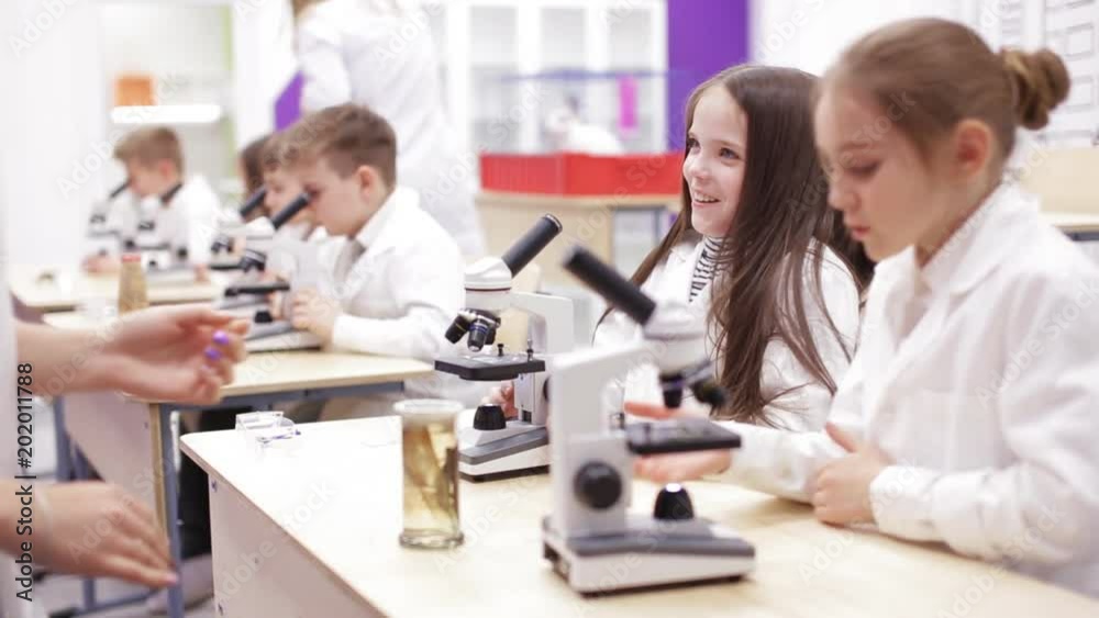 Schoolboys looking through microscope in laboratory Schoolboys looking through microscope in laboratory