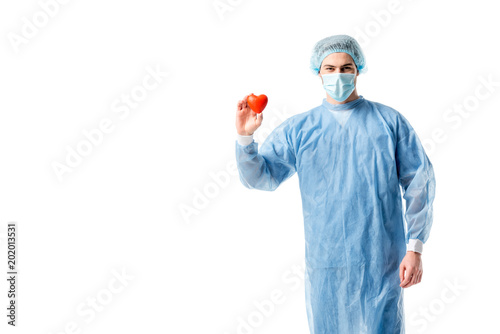 Man wearing blue medical uniform and medical mask and holding toy heart isolated on white