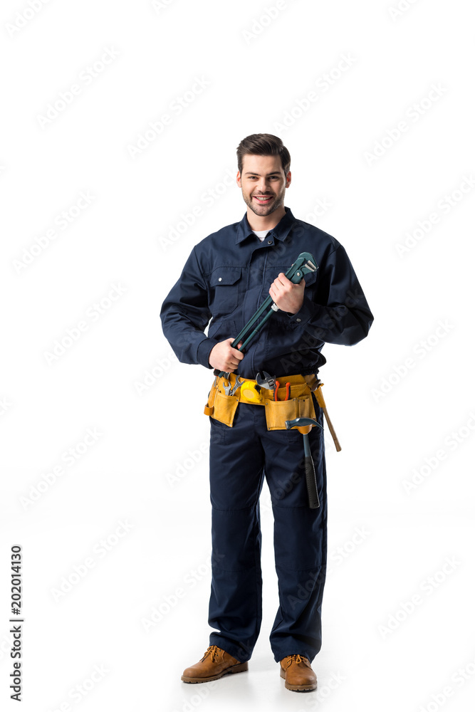 Confident handyman wearing uniform with tool belt and holding wrench isolated on white Confident handyman wearing uniform with tool belt and holding wrench isolated on white