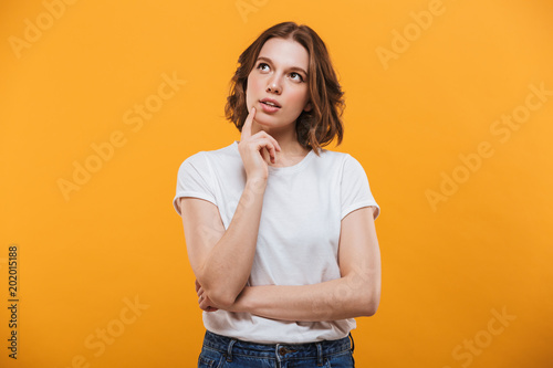 Thinking cute young woman standing isolated