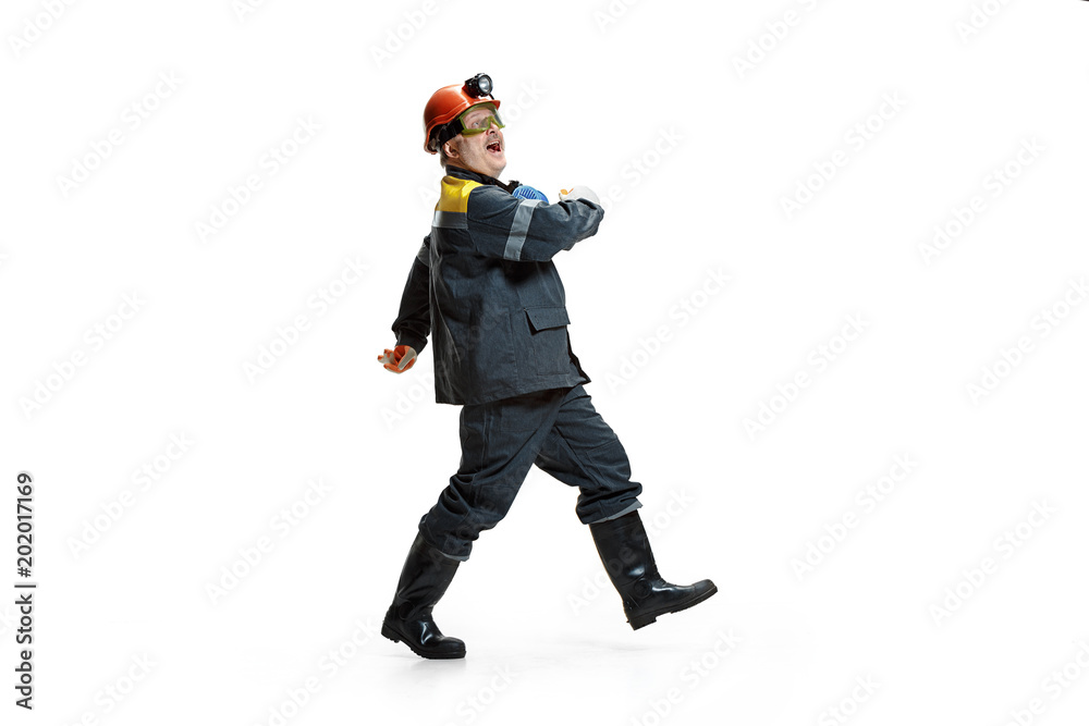 The studio shot of senior bearded male miner standing at the camera on a white background. The studio shot of senior bearded male miner standing at the camera on a white background.