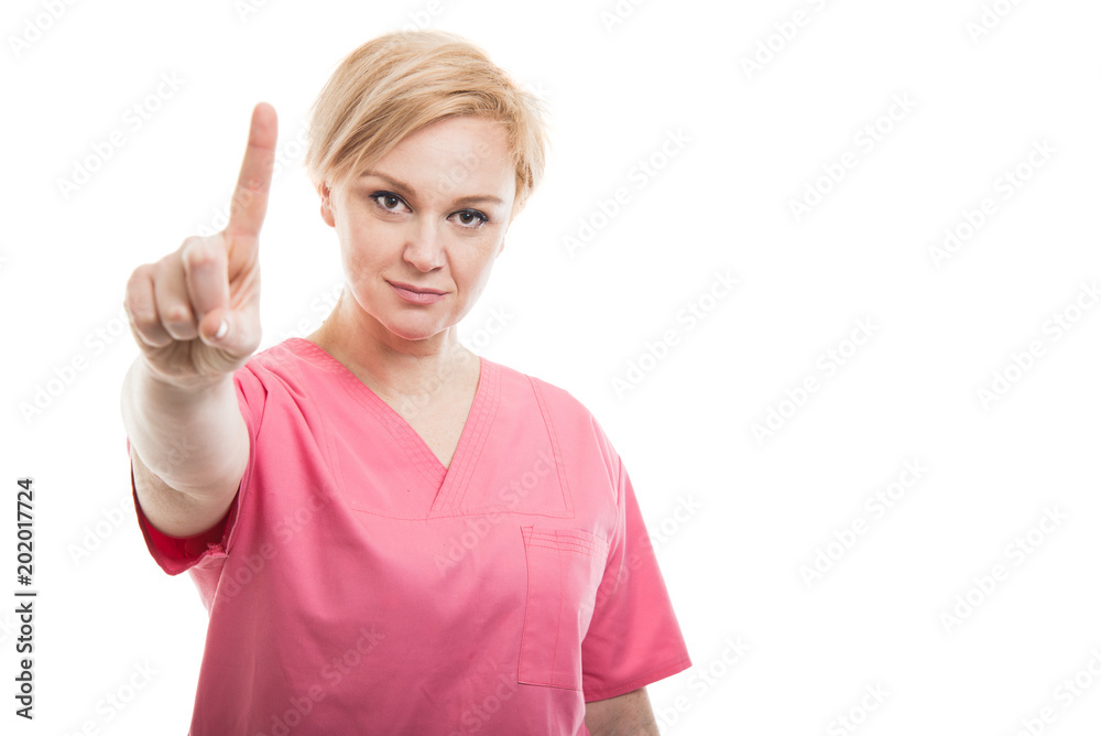 Attractive female nurse wearing pink scrubs showing number one Attractive female nurse wearing pink scrubs showing number one