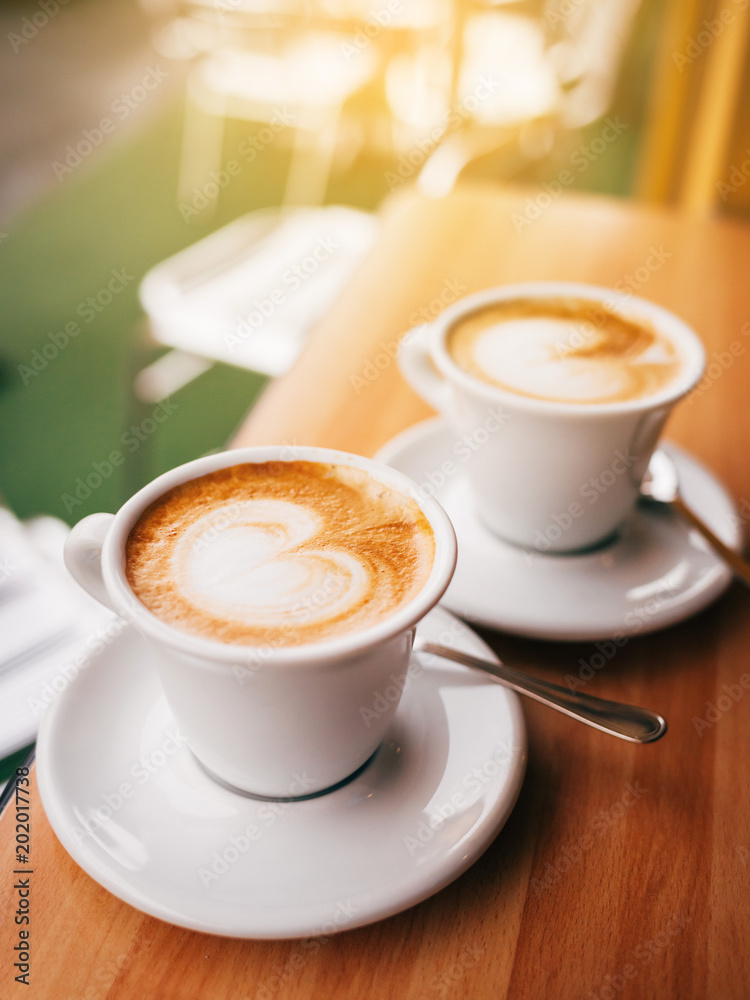Premium Photo  Two glasses coffee cup with cappuccino in morning on white  table with latte art aroma ristretto mug of coffee glass close up top view  ceramic cup of coffee on